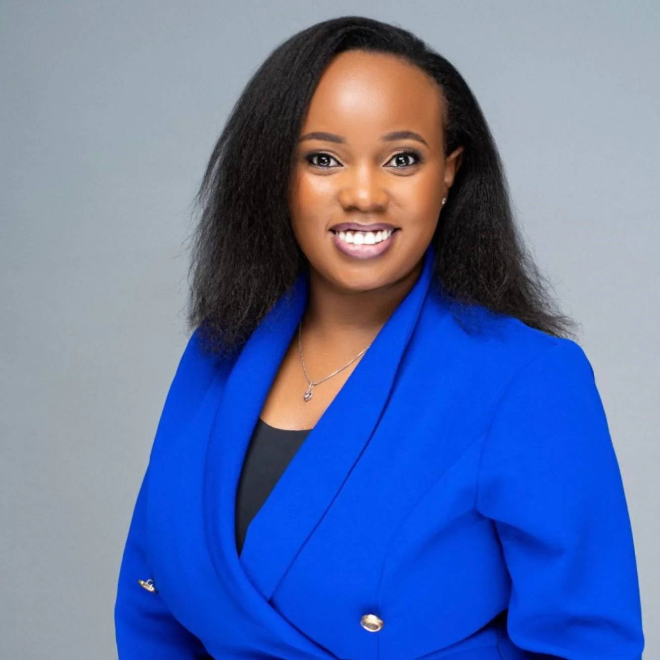 Headshot of woman wearing a blue blazer smiling at the camera.
