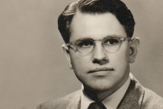 Black and white image of Eric Lampard as a young man. He is wearing a suit and glasses