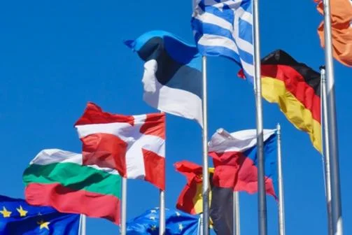 EU country flags and EU flags flying against blue sky