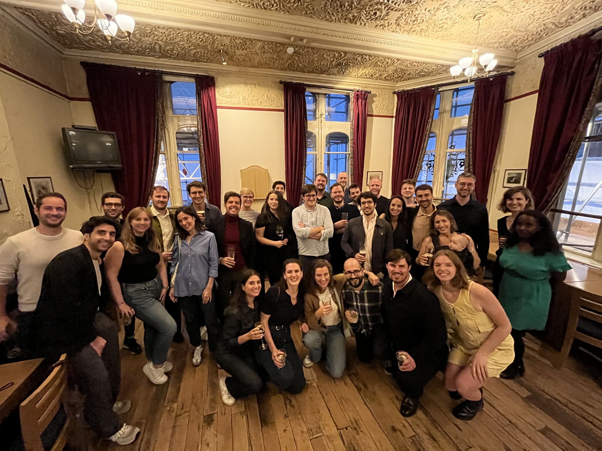 group of people smiling and holding drinks 