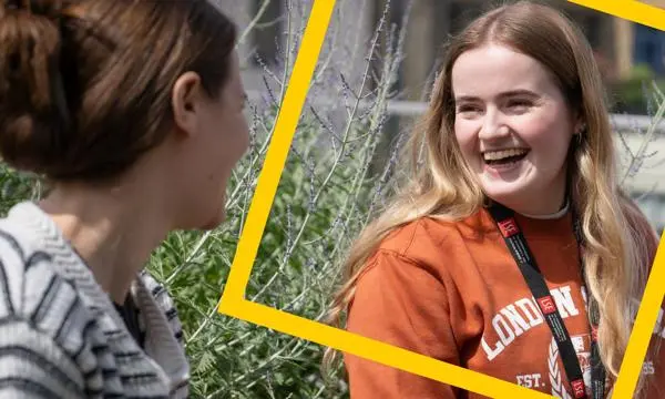 Woman in orange LSE jumper smiling
