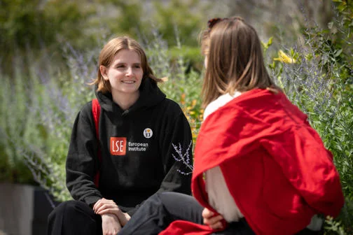 Two students chatting on a bench