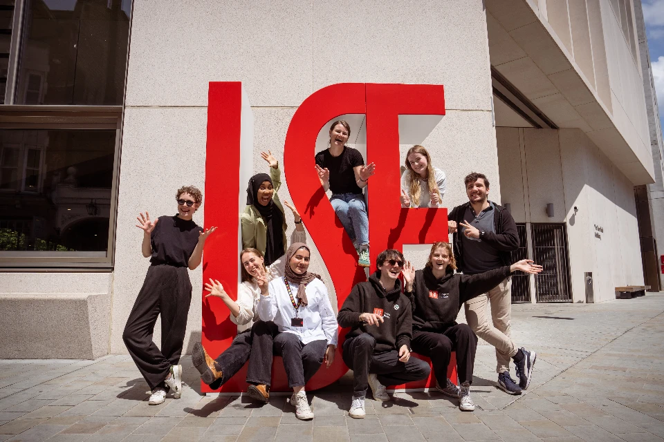 Students standing in front of LSE sign