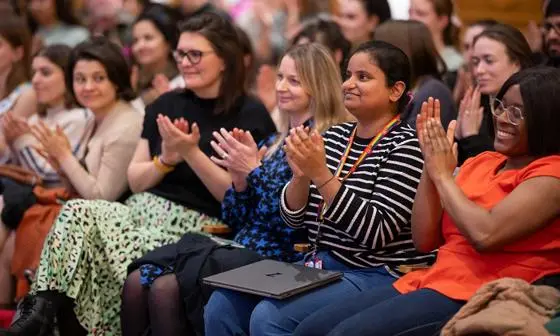 Audience at an LSE event clapping and smiling.