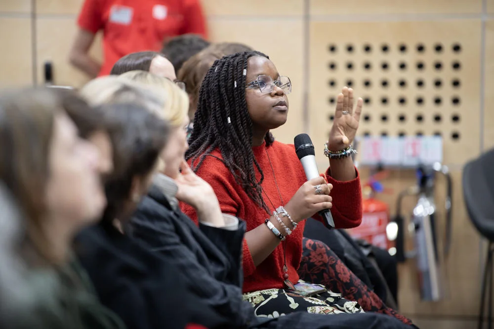 Women asking a question at a public event