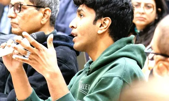 Young man in audience holding microphone and speaking