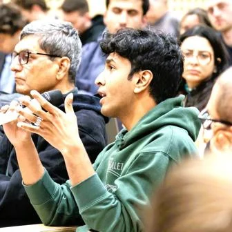 Young man in audience holding microphone and speaking