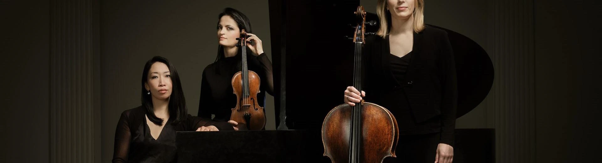 Greenwich Trio stand together with their instruments