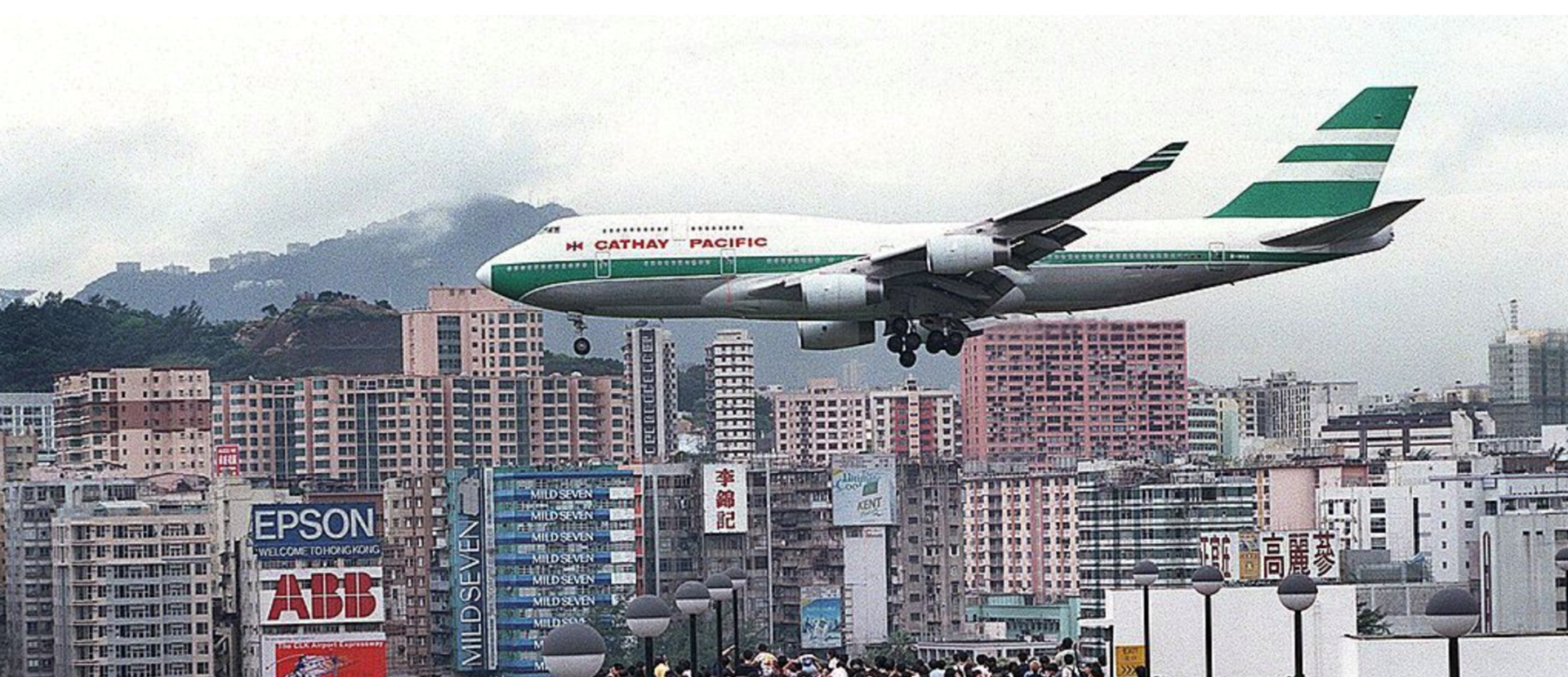 A plane flying through Honk Kong buildings about to land