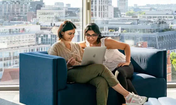 To students on a sofa looking at a laptop