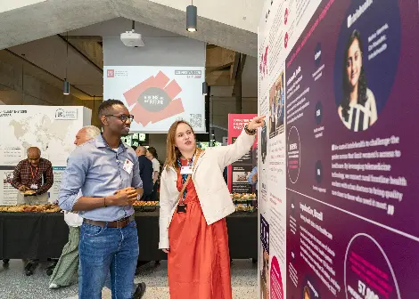 A researcher shows an exhibition visitor her research