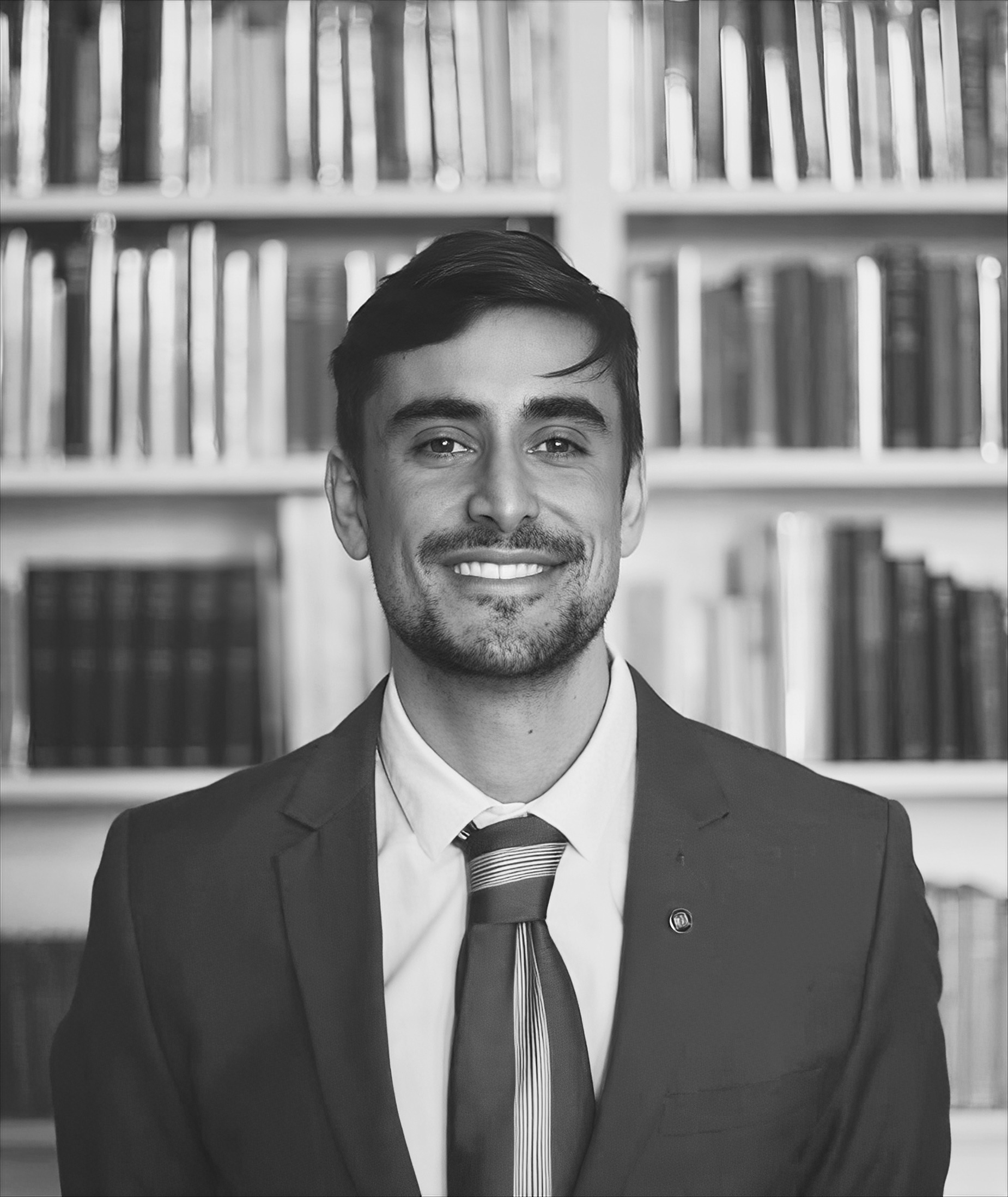 Francisco González Centeno smiling wearing a suit and tie. The photo is black and white.