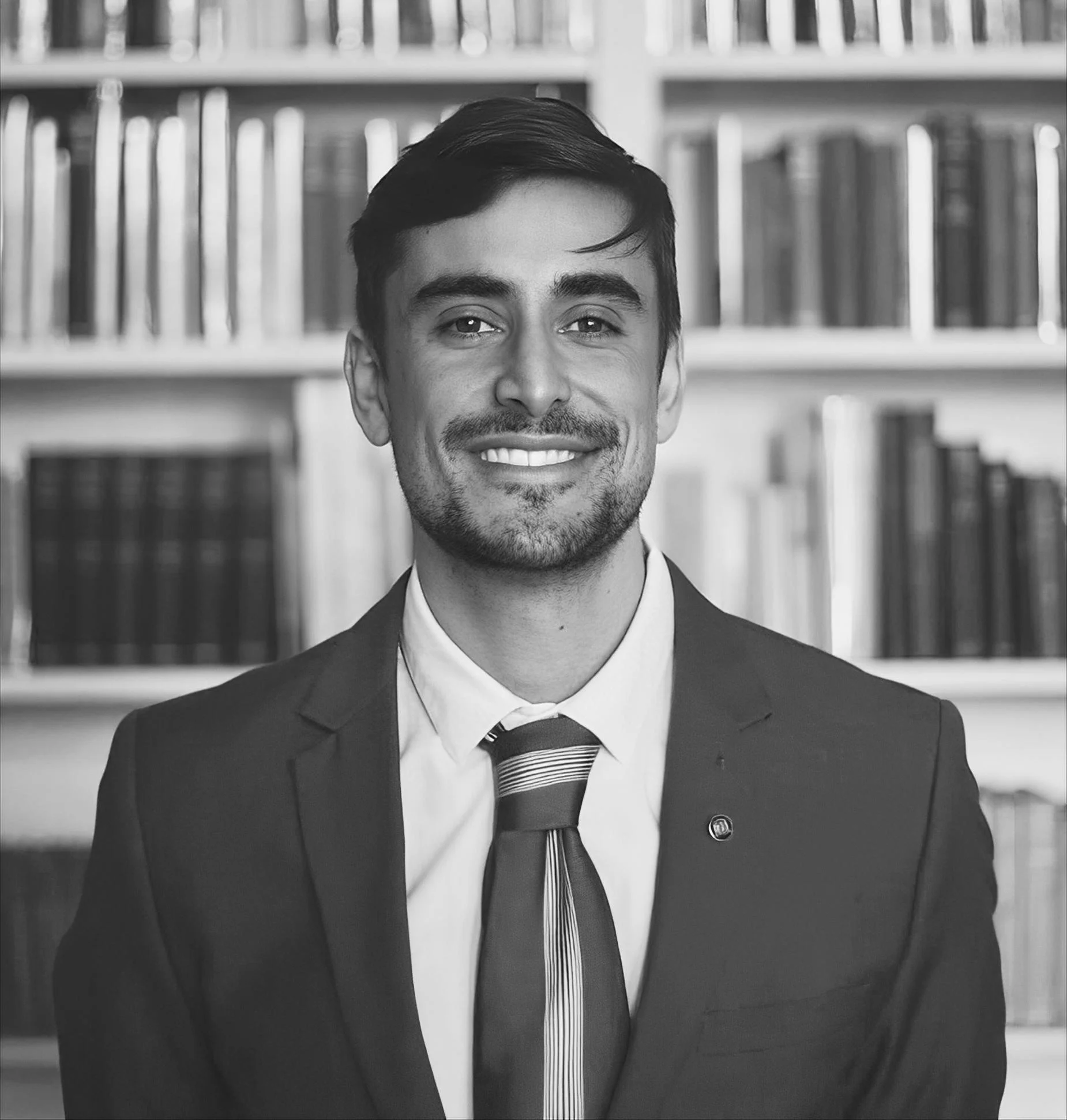 Francisco González Centeno smiling wearing a suit and tie. The photo is black and white.