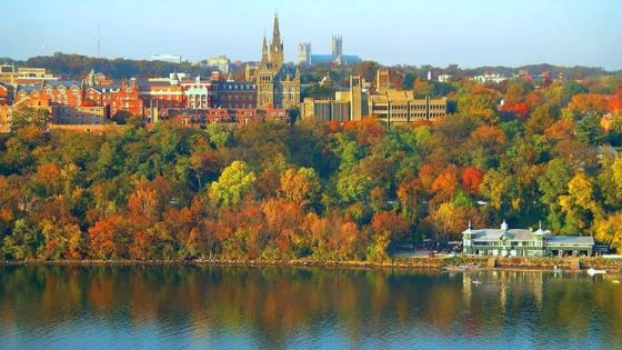 View of Georgetown University on a hillside in autumn, with colourful trees in shades of orange, red, and yellow