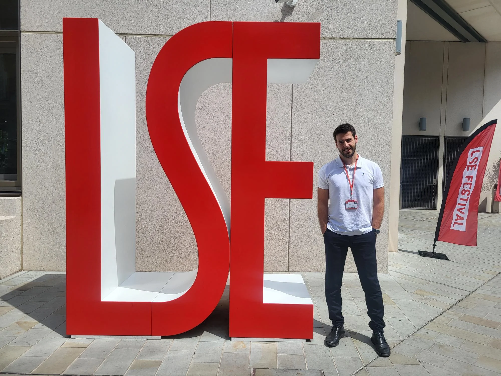 Participant of the CIVICA staff visit scheme standing beside the iconic LSE letters on campus during the LSE Festival.