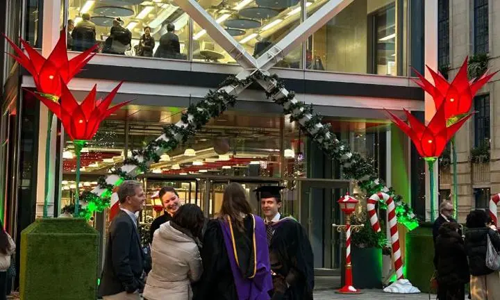 Graduates in front of Centre Building with Christmas decorations in the background