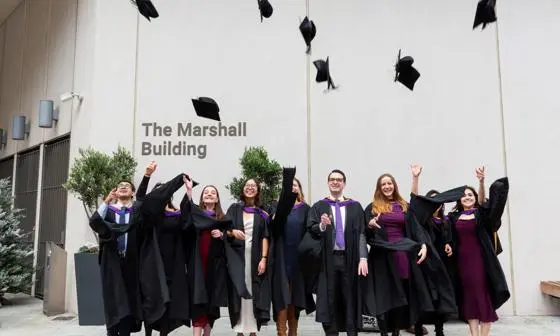 students throwing caps in air at graduation