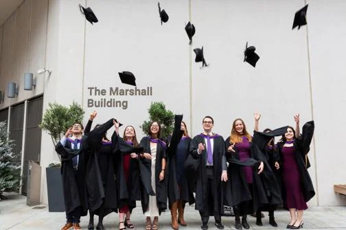 students throwing caps in air at graduation