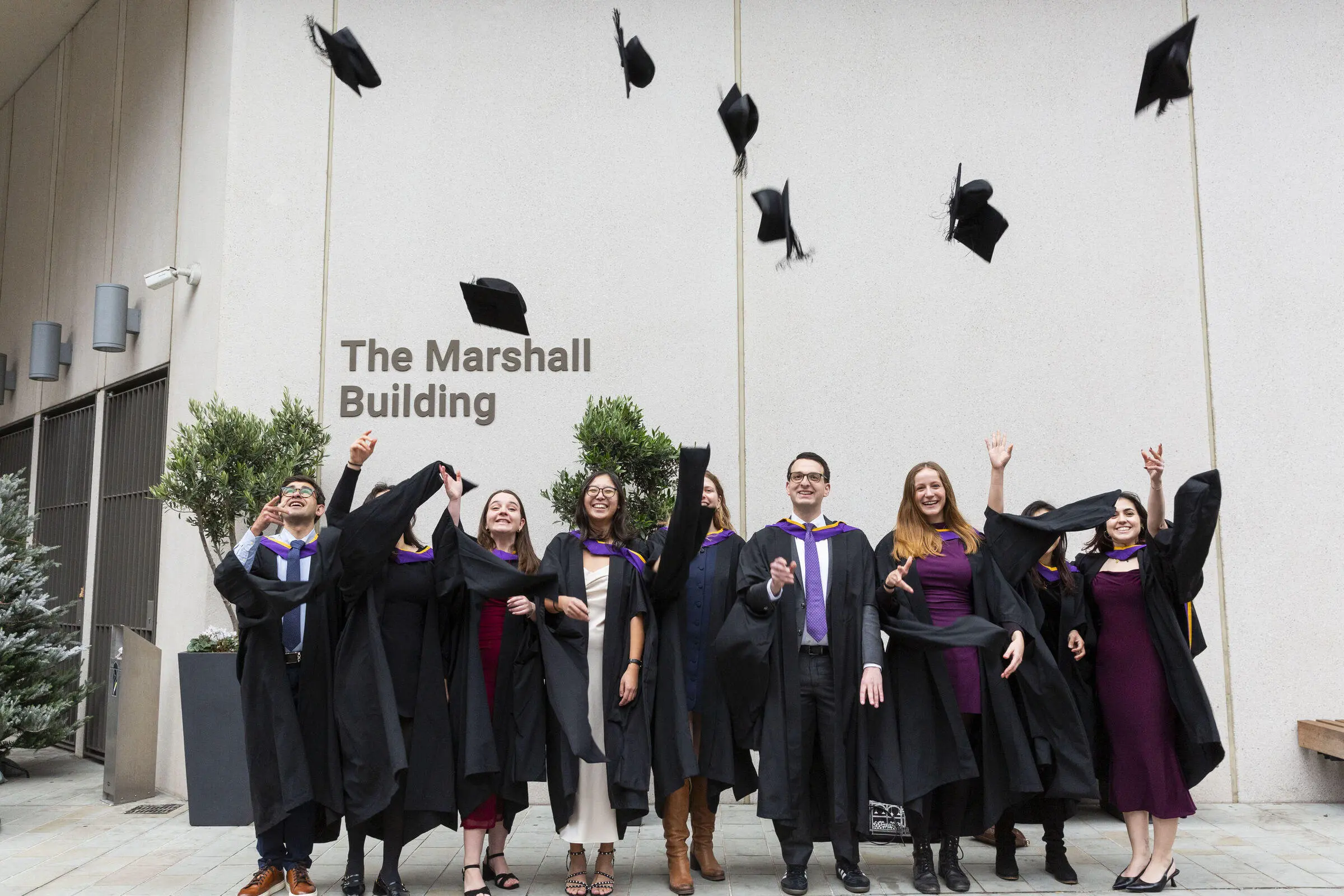 LSE graduates celebrate by throwing their caps in the air