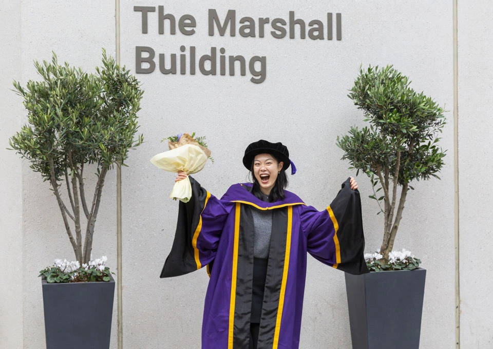 An LSE graduate celebrating on campus