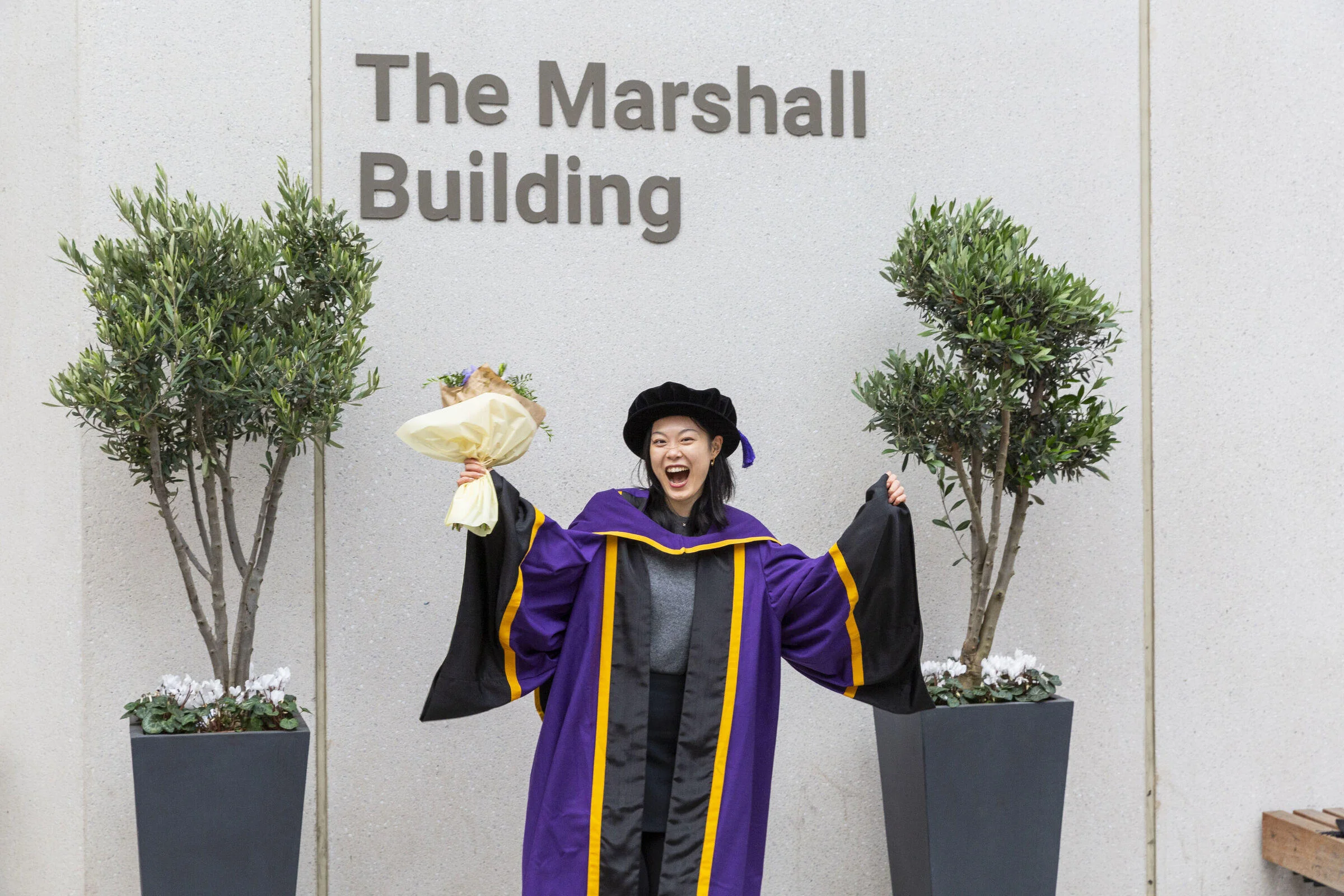 An LSE graduate celebrating on campus