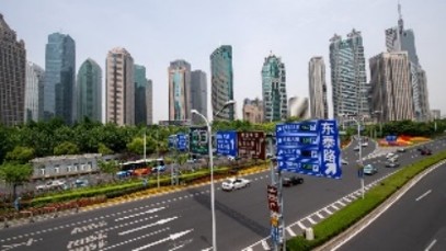 Modern city skyline with tall skyscrapers overlooking a busy multi-lane urban road
