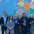 Group of 7 academics standing in front of the large globe sculpture on the LSE campus
