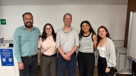 Group of academics posing together indoors in an office or classroom setting at the partner university in Mexico 