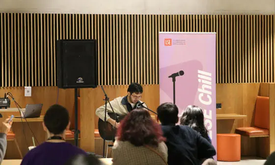 student performing guitar and singing at LSE Chill