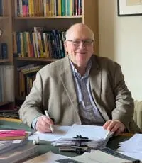 Henry Wynn sitting at a desk, pen in hand.