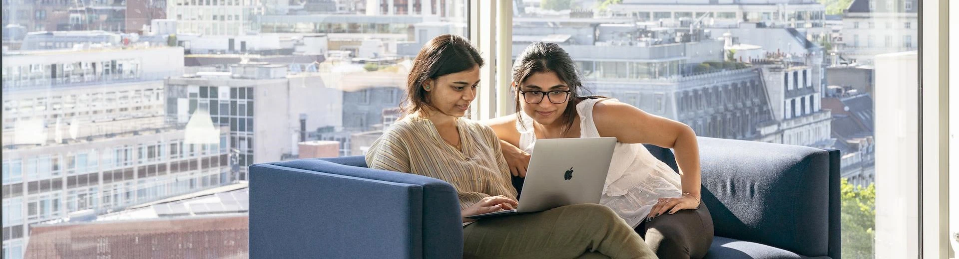 Two students looking at a laptop
