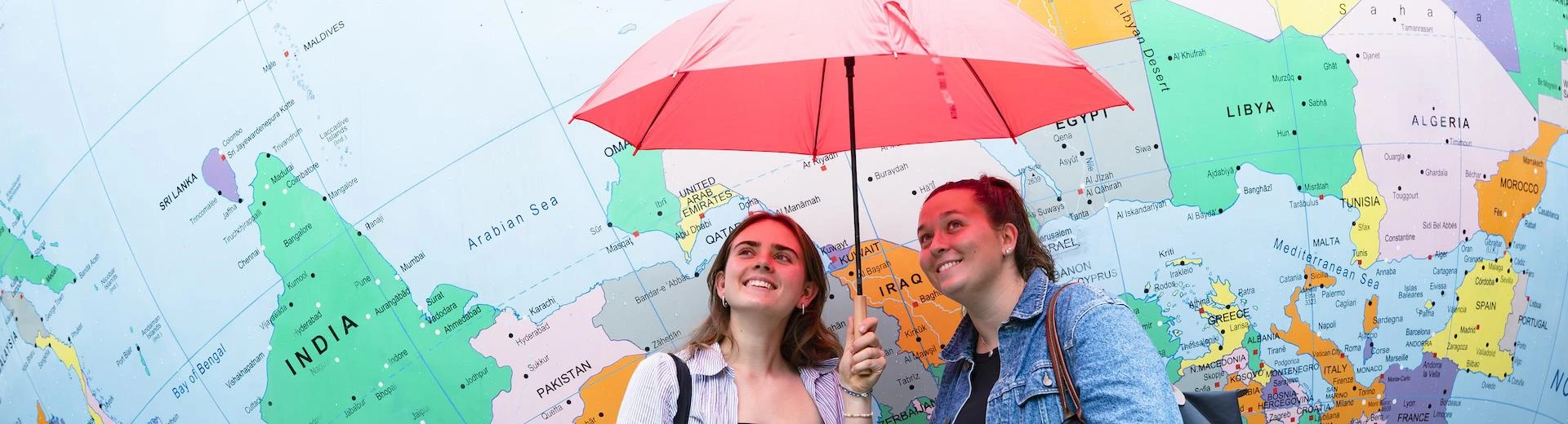 Two students under an umbrella