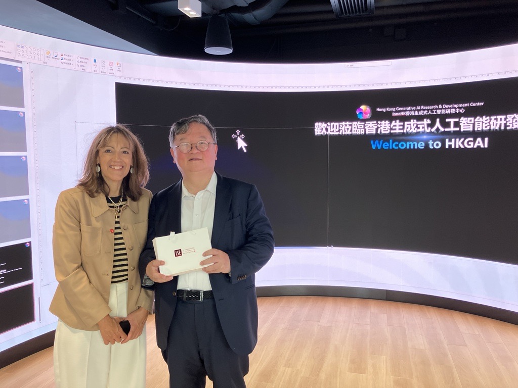 LSE's Professor Susana Mourato posing with Provost of HKUST, Professor Guo Yike, in front of a screen that says 'Welcome to HKGAI.' 