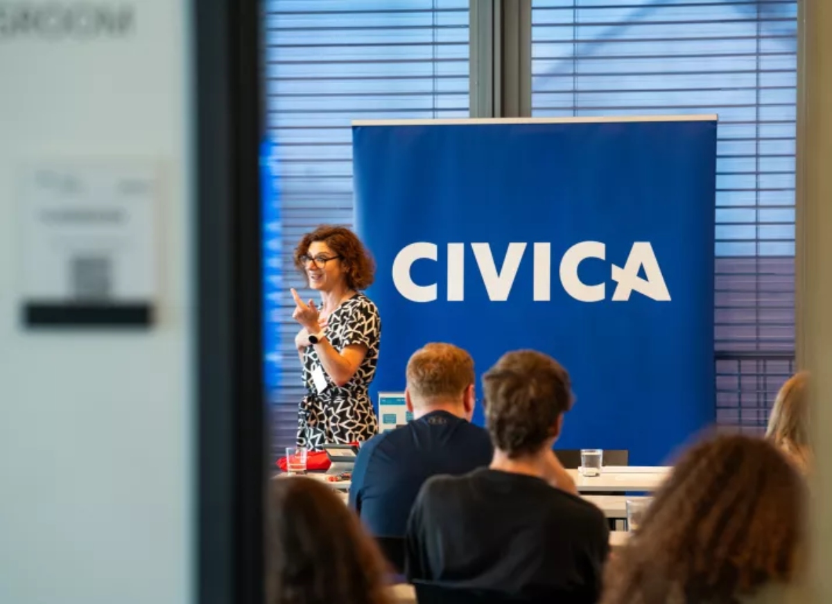 Lecturer teaching her class next to CIVICA banner
