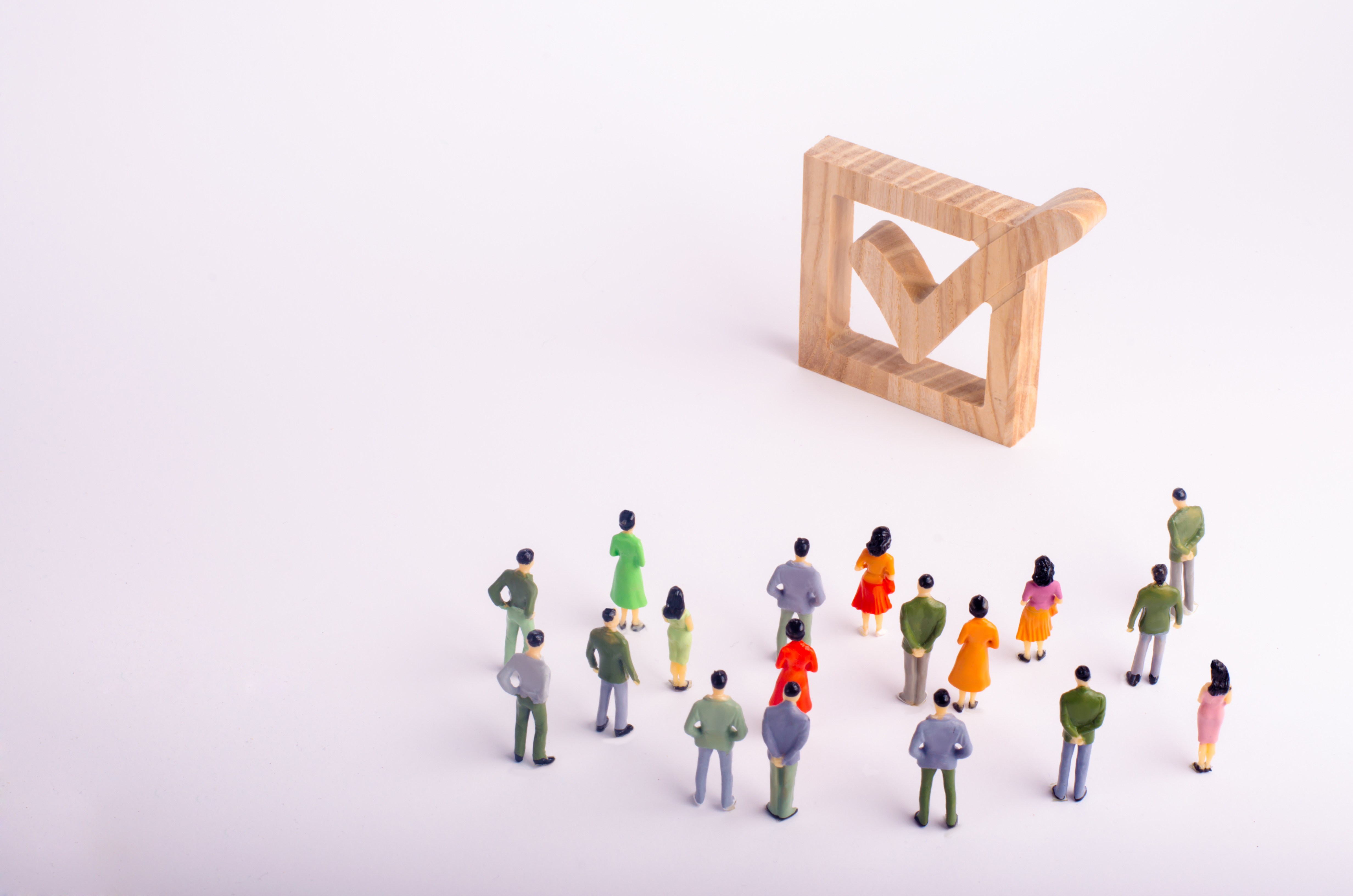 Human figures stand together next to a tick in the box. 