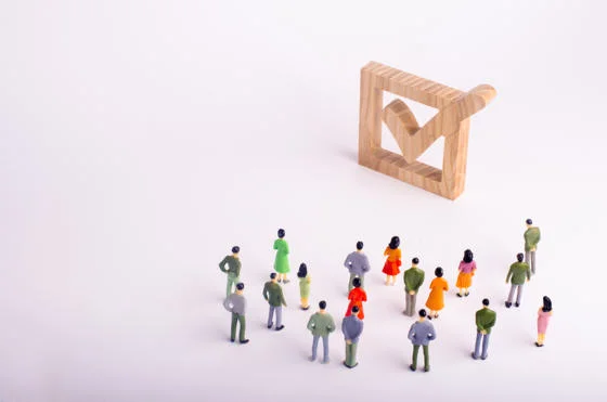 Human figures stand together next to a tick in the box.