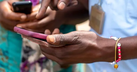 Two people holding mobile phones in Kigali, Rwanda to illustrate the digital transition to a cashless economy using mobile payments. Photo by Godong/Universal Images Group via Getty Images.