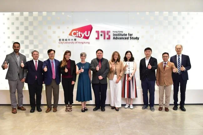 11 individuals posing in front of a wall with the 'City University of Hong Kong' and 'Hong Kong Institute for Advanced Study' logo.