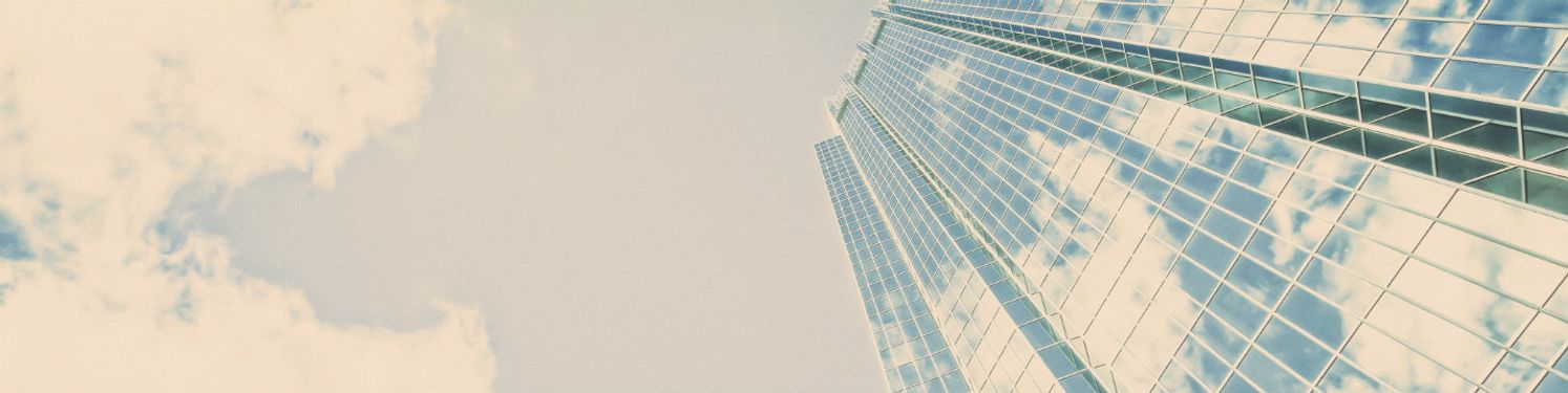 A tall skyscraper with clouds