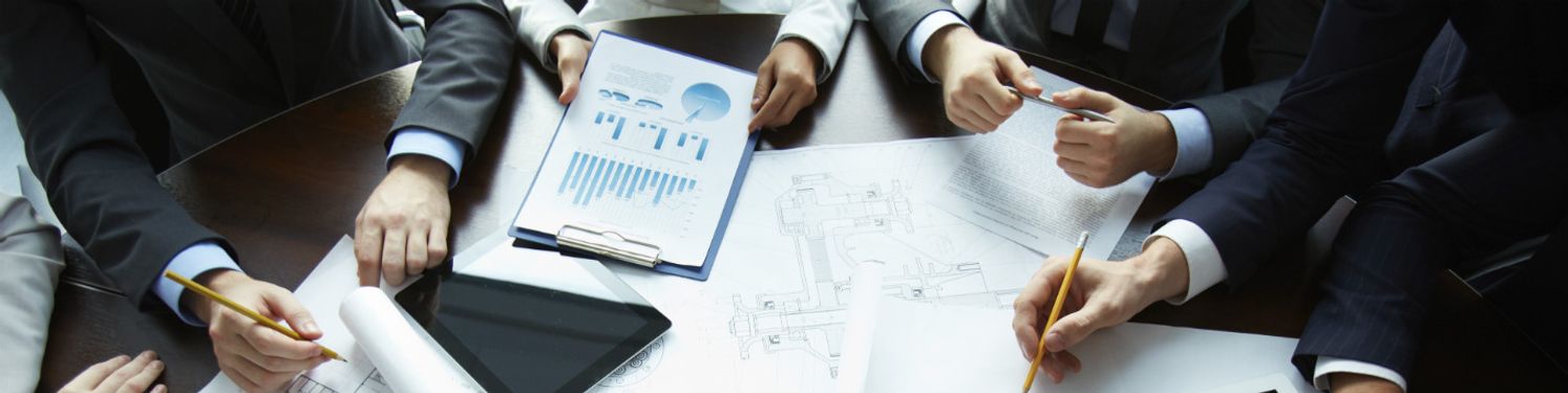 professionals at a desk going through paperwork