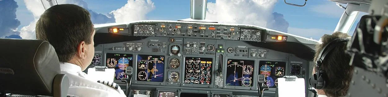 two pilots in a cockpit flying a plane