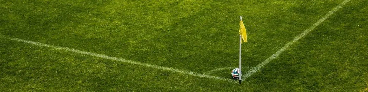A football field with a ball positioned by a post.