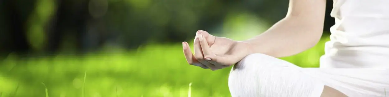 a woman meditating on the grass