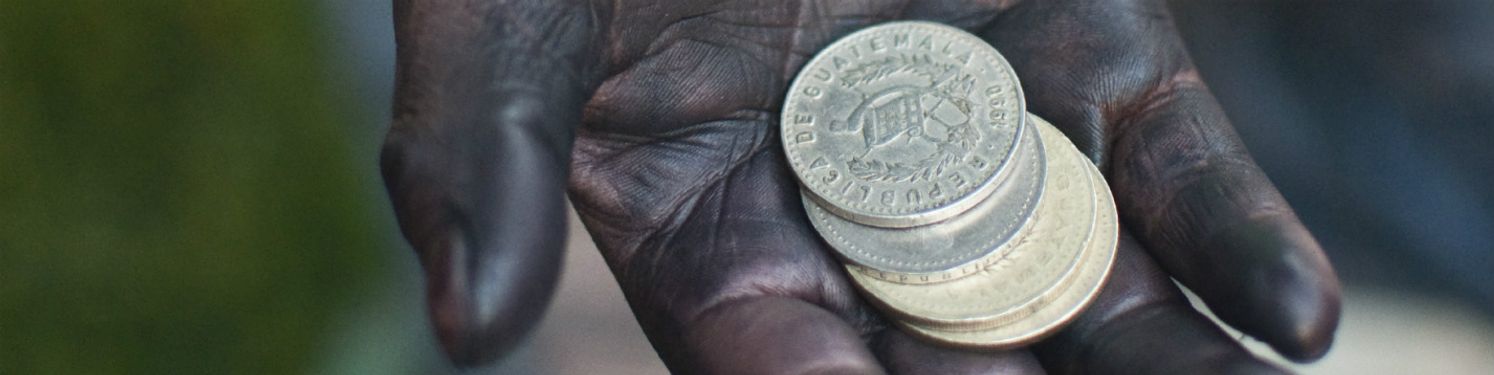 a hand covered in oil holding coins