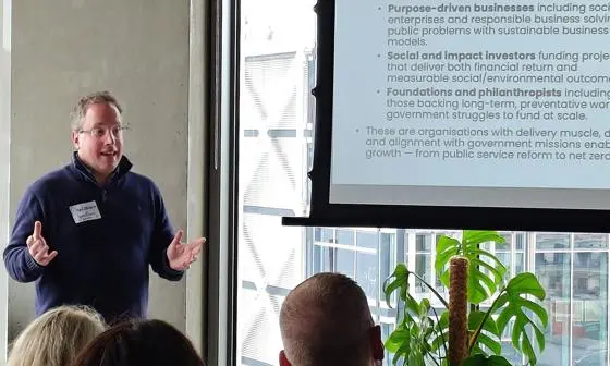 Man stands in front of a slide teaching