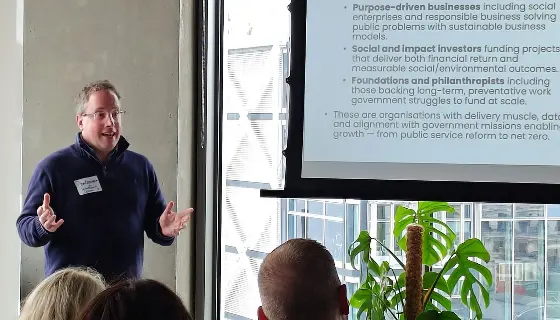 Man stands in front of a slide teaching