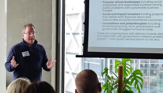 Man stands in front of a slide teaching
