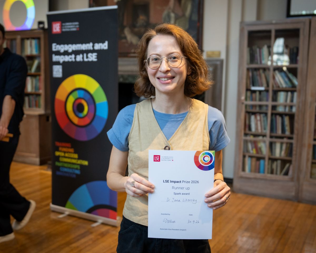 Dr Yana Litovsky holding her LSE Impact Prize certificate. 