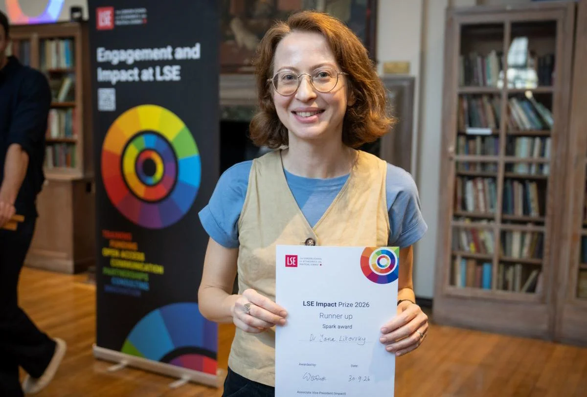 Dr Yana Litovsky holding her LSE Impact Prize certificate.