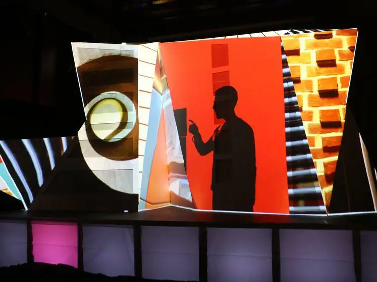 Light display projecting still images onto a 3D shape of the LSESU Saw Swee Hock Student Centre.